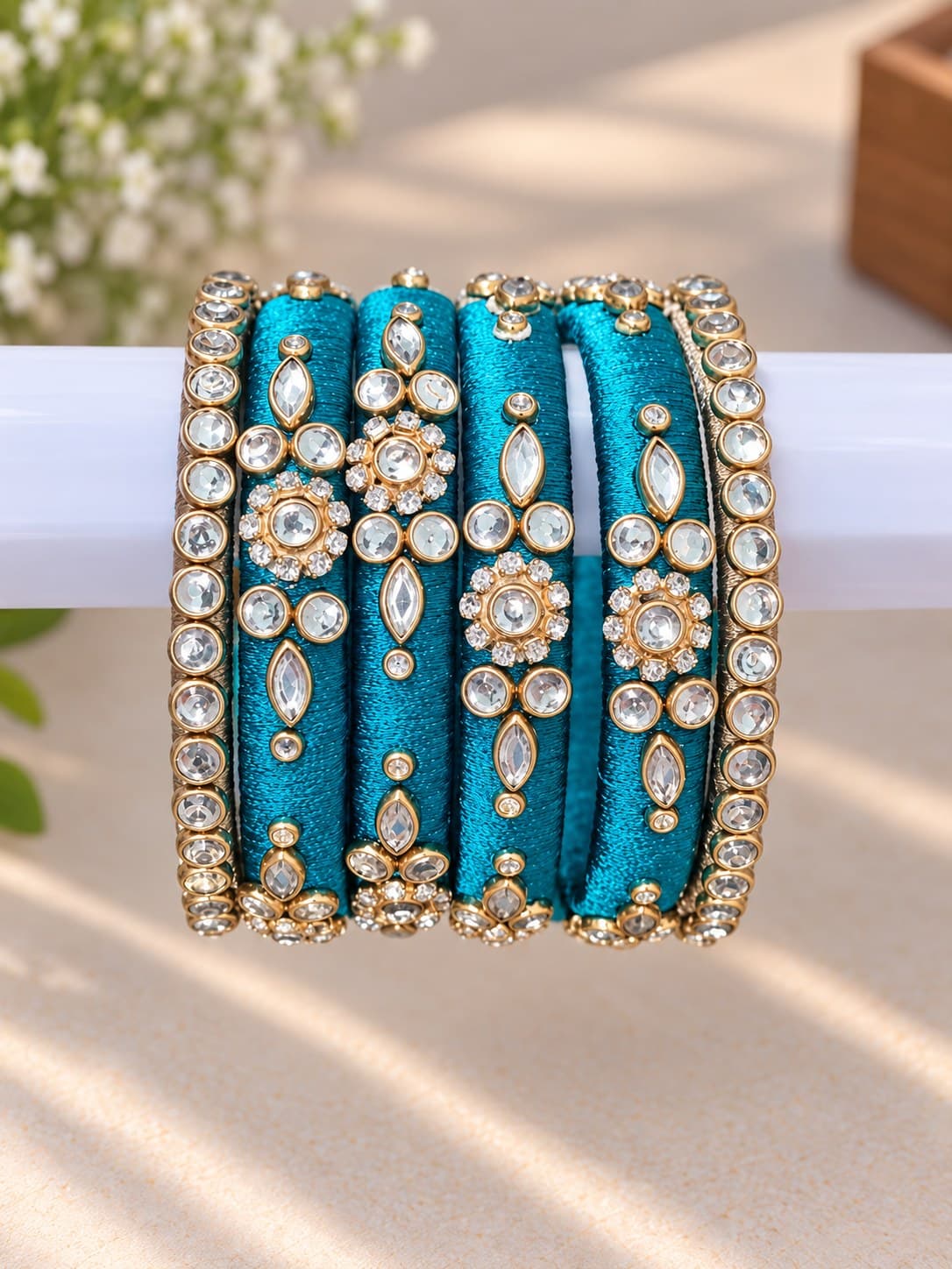 Close craftsmanship detail of teal silk bangles
